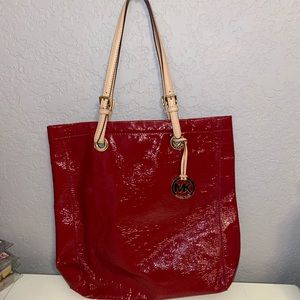 Large glossy red Michaela kors tote, with gold interior